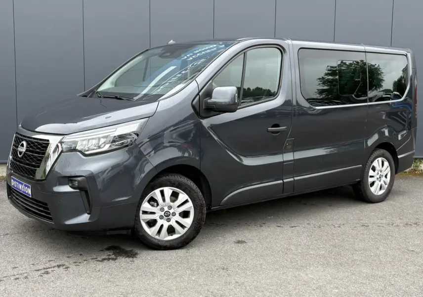 Vue 3/4 avant droit d’un Nissan Primastar gris comète avec hayon vitré et jantes alliage 17 pouces.