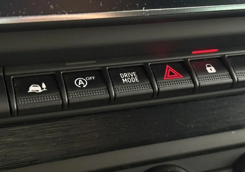 Gros plan sur les boutons de commande noirs du tableau de bord du Nissan Primastar gris Comète, version 2025.