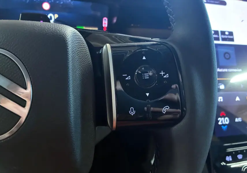 Gros plan sur les commandes tactiles noires à droite du volant d’un Citroën C5 Aircross gris hybride 2026.