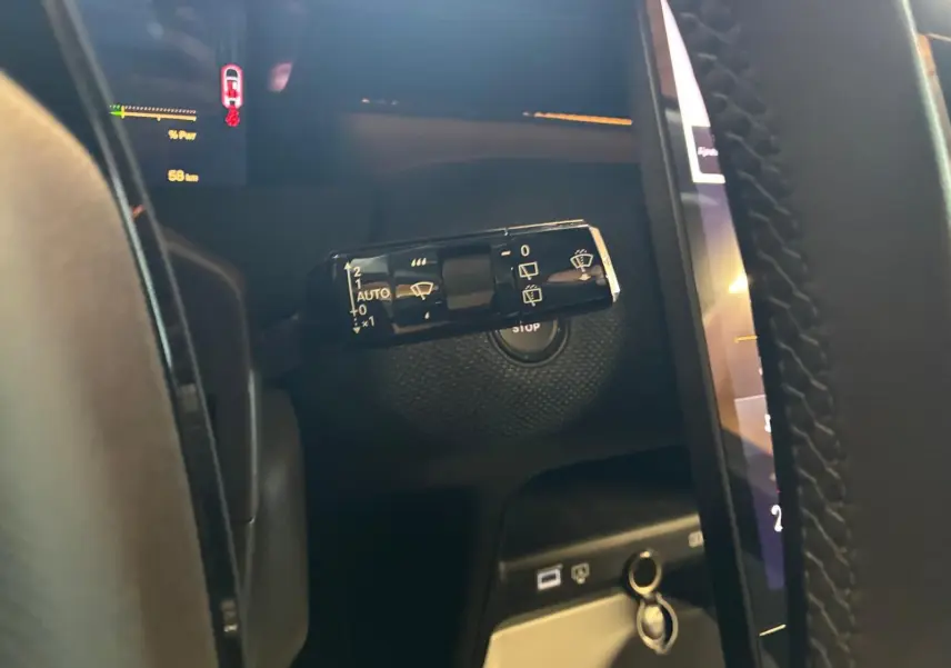 Gros plan sur la commande d’essuie-glace à gauche du volant dans l’habitacle sombre du Citroën C5 Aircross gris.