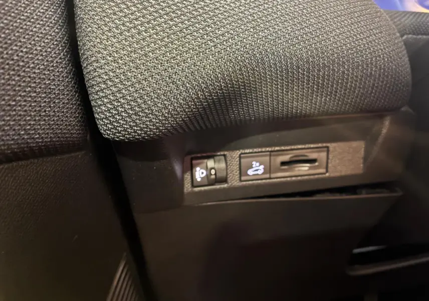 Détail des commandes sous le siège avant d’un Citroën C5 Aircross gris, version hybride 2026.