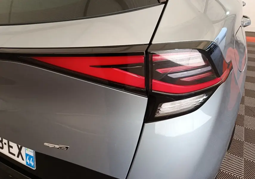 Gros plan sur le feu arrière droit et le logo GT-Line d’un Kia Sportage gris clair, vue arrière côté droit.