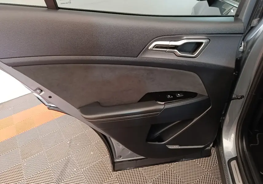 Vue intérieure de la porte arrière droite gris clair du KIA SPORTAGE 2022 avec garniture noire et commandes de fenêtre.