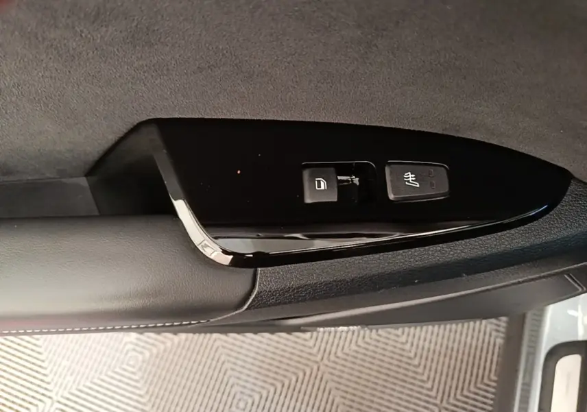 Gros plan sur les commandes de verrouillage et dégivrage du rétroviseur côté conducteur du Kia Sportage gris clair 2022.