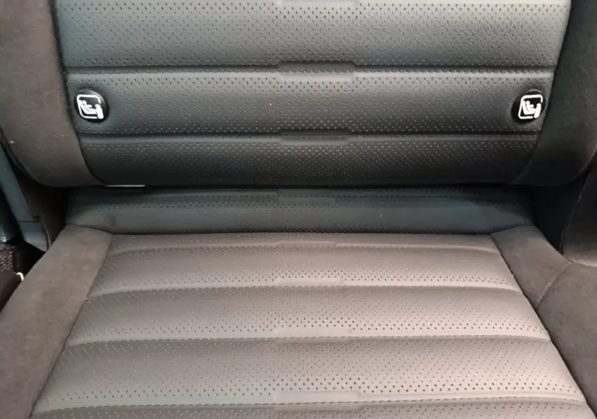 Gros plan sur l’assise arrière en cuir perforé gris foncé du Kia Sportage 2022, avec ancrages Isofix visibles.