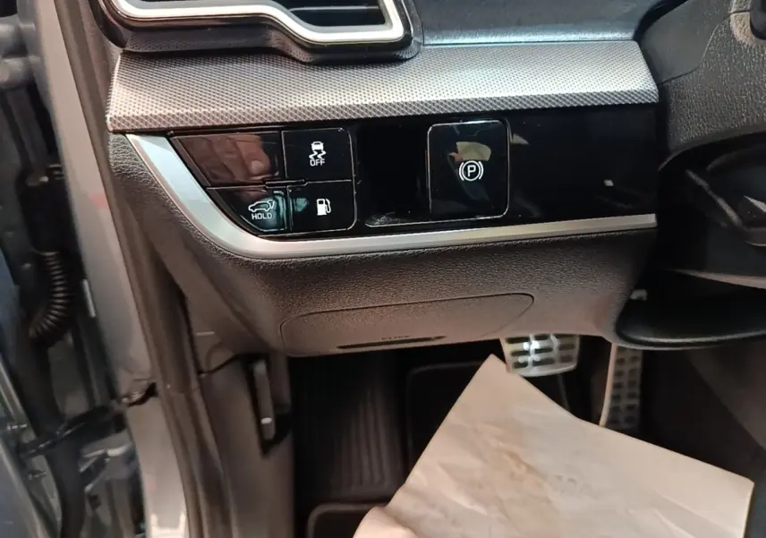 Détail intérieur côté gauche avec commandes électroniques et finition noire brillante du Kia Sportage gris clair 2022.