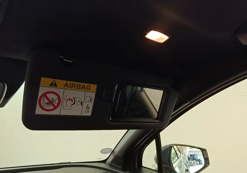 Vue intérieure côté conducteur du Kia Sportage 2022, miroir pare-soleil ouvert avec avertissement airbag visible.