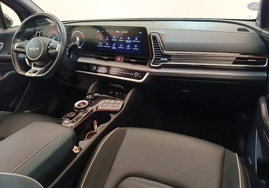 Intérieur avant du Kia Sportage 2022 gris clair, tableau de bord moderne avec écran tactile large et volant multifonctions.