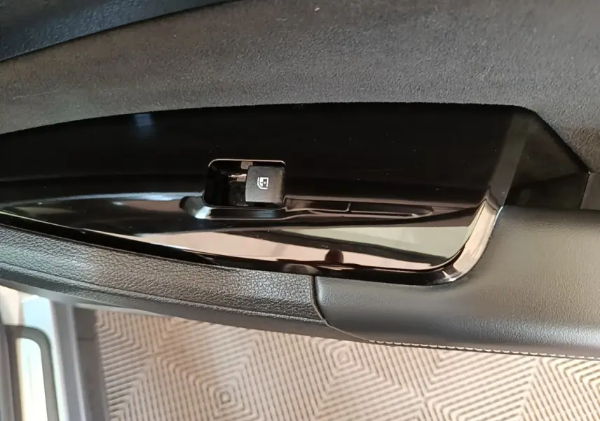 Gros plan sur le bouton de commande de lève-vitre côté conducteur du Kia Sportage gris clair 2022.