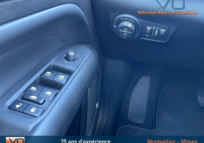 Vue rapprochée du panneau de commandes côté gauche du Jeep Compass blanc 2024 avec réglages vitres et phares automatiques.