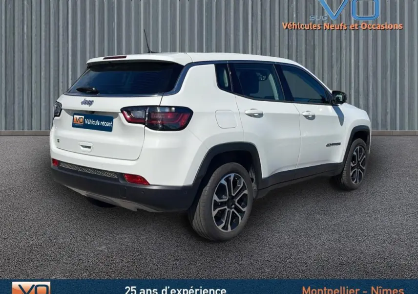 Vue 3/4 arrière droite d'un Jeep Compass blanc 2024 avec jantes alliage 18 pouces et vitres teintées.