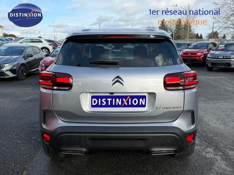 Vue arrière d'un Citroën C5 Aircross gris 2024 avec feux rouges distinctifs et logo au centre du hayon.