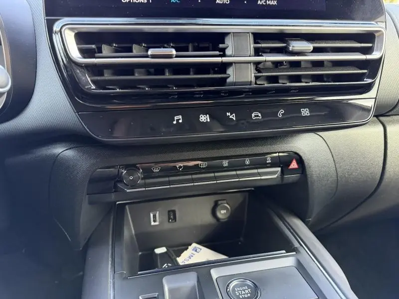 Vue rapprochée de la console centrale du Citroën C5 Aircross 2024 gris, avec commandes climatisation et bouton start/stop.