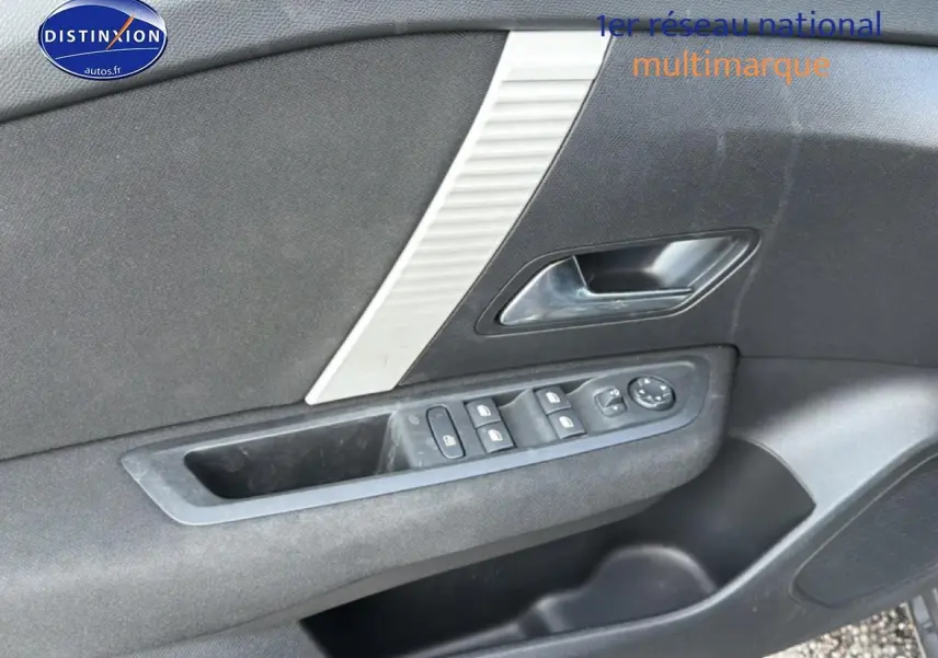 Intérieur côté gauche de la porte avant d'une Citroën C4 électrique 2025, avec commandes de vitres et poignée gris foncé.