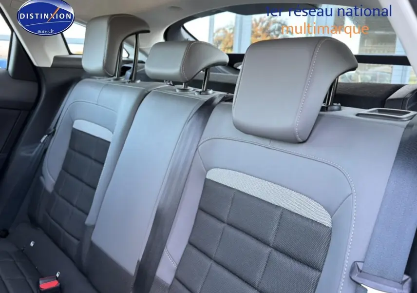 Vue intérieure de la banquette arrière gris foncé et noir de la Citroën C4 électrique 2025 avec appuie-têtes réglables.