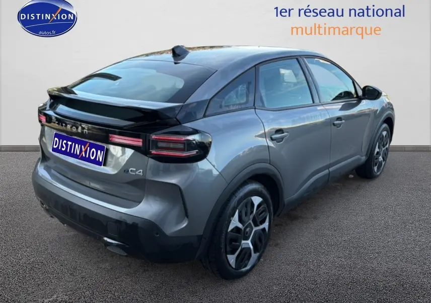 Vue 3/4 arrière droite d'une Citroën C4 électrique gris foncé avec feux arrière LED et jantes stylisées.