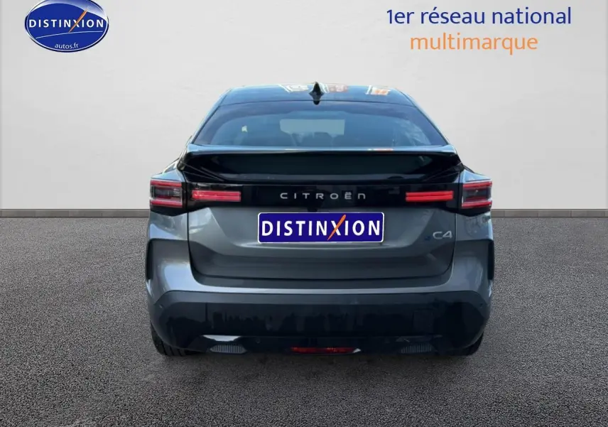 Vue arrière du Citroën C4 électrique gris foncé avec feux LED et logo distinctif sur fond neutre.
