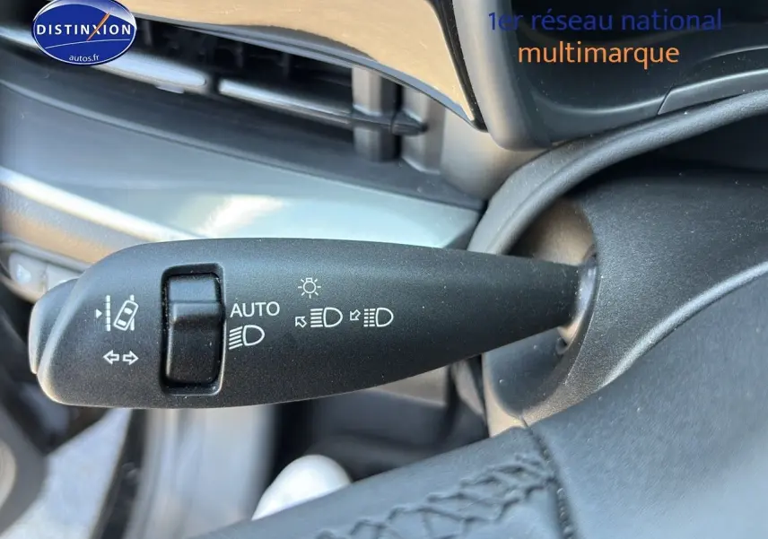 Gros plan sur la commande des feux et clignotants du tableau de bord de la Fiat 500 électrique blanche 2024.