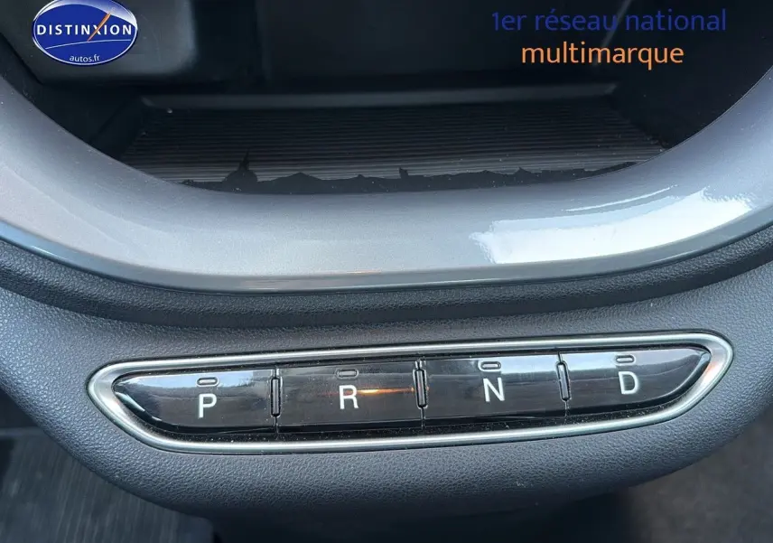 Gros plan sur la commande de boîte automatique en boutons de la Fiat 500 électrique blanche, version 2024.