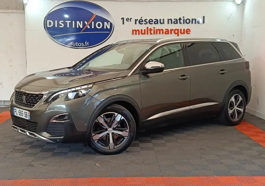 Peugeot 5008 BlueHDi 180 gris clair en 3/4 avant droit, avec jantes alliage et calandre chromée visible.