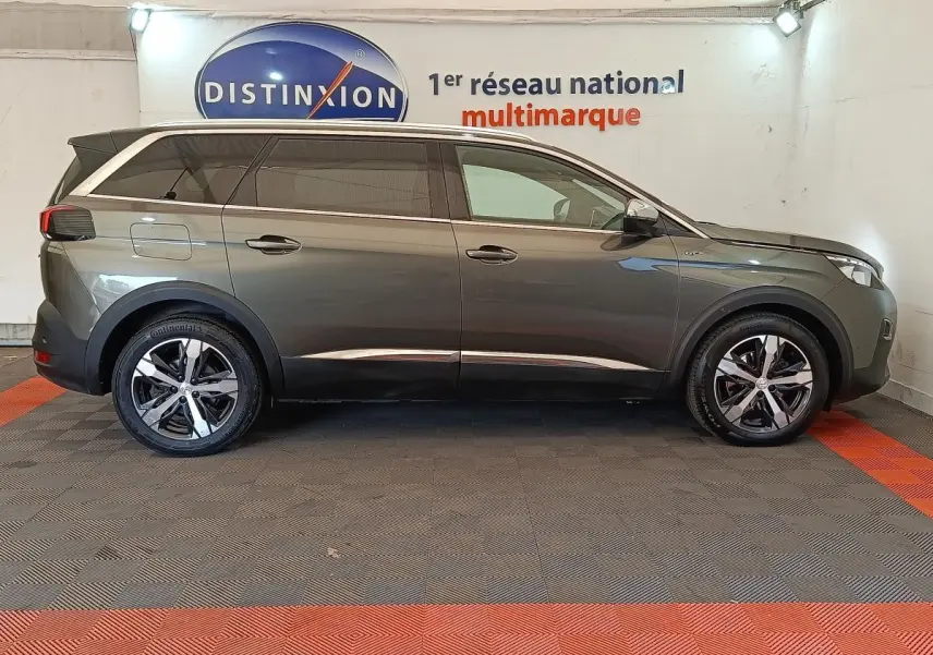 Peugeot 5008 gris clair vue de profil côté gauche, avec jantes alliage et toit noir contrasté.