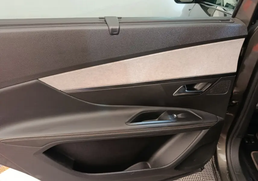 Vue intérieure de la porte avant droite du Peugeot 5008 gris clair, avec garniture noire et insert gris clair.