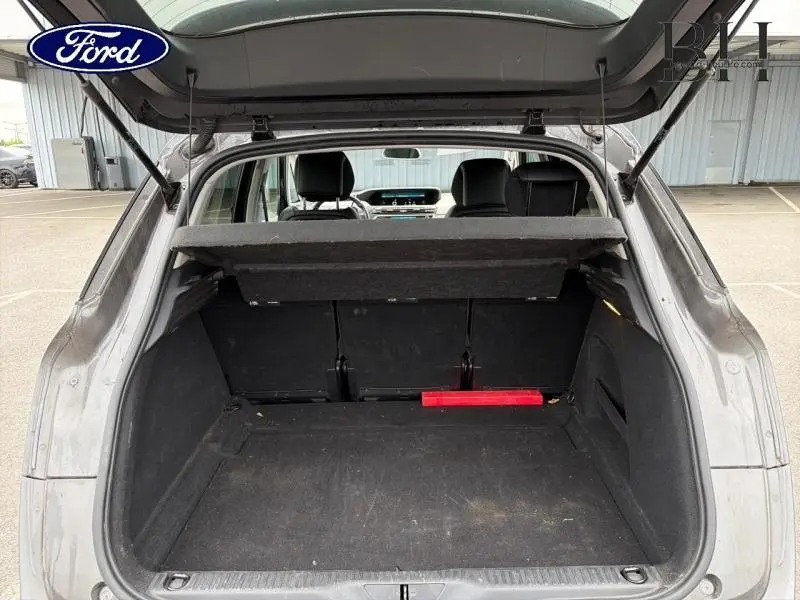 Coffre ouvert vu de l'arrière d'une Citroën C4 Spacetourer gris Platinium avec banquette arrière et tablette de coffre.