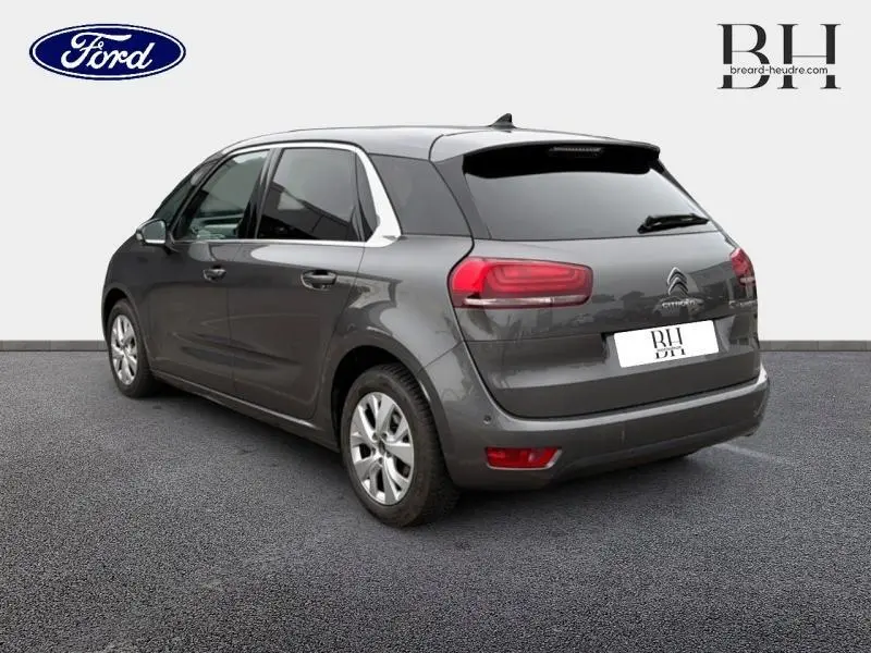 Vue 3/4 arrière droite d'une Citroën C4 Spacetourer gris Platinium avec vitres arrière surteintées et jantes alu.