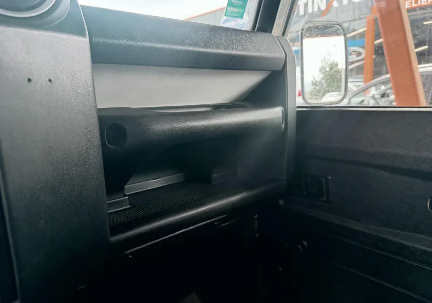 Détail de la boîte à gants et de la portière côté passager intérieur du Land Rover Defender blanc de 2007.
