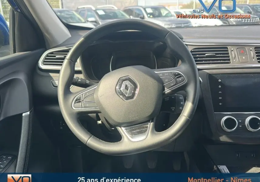 Vue intérieure centrée sur le volant de la Renault Kadjar TCe 140 Business, avec tableau de bord et écran tactile visibles.