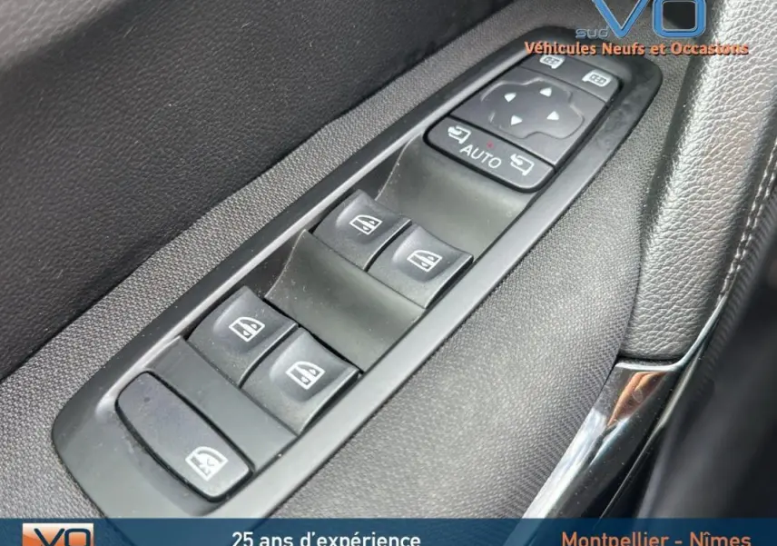 Gros plan sur les commandes électriques des vitres côté conducteur du Renault Kadjar bleu foncé 2021.