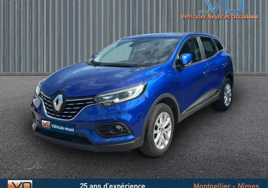Renault Kadjar TCe 140 bleu foncé vu en 3/4 avant droit avec jantes alliage et barres de toit visibles.