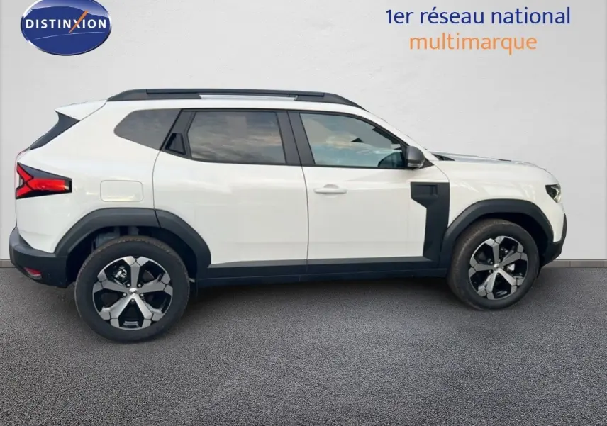 Profil droit du Dacia Duster blanc glacier 2025 avec jantes bi-ton et protections noires contrastantes.