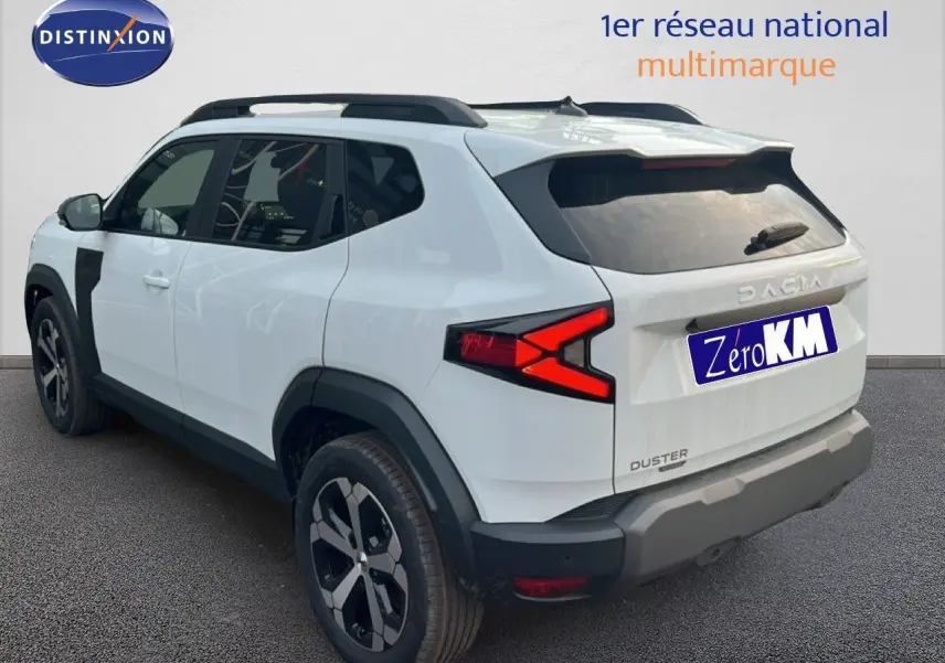 Vue 3/4 arrière droite du Dacia Duster blanc glacier 2025 avec jantes biton et feux arrière distinctifs en X.