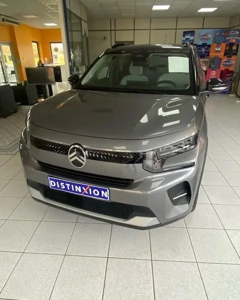 Citroën C3 turbo 100cv gris Mercury vue 3/4 avant en intérieur, avec calandre noire et phares LED distinctifs.