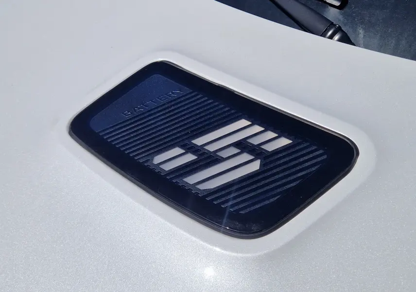 Gros plan sur l’inscription "BATTERY" sur la carrosserie blanc nacré de la Renault R5 E-TECH TECHNO 2025.