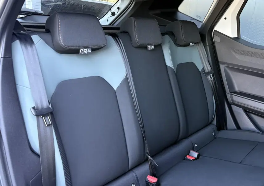 Vue intérieure de la banquette arrière bi-ton noire et grise du Dacia Duster 2026 avec ceintures et appuie-têtes.