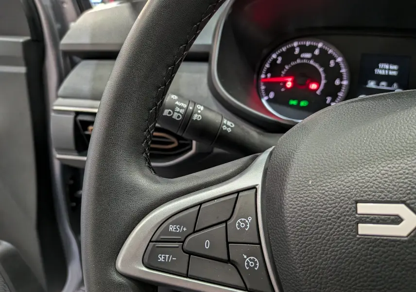 Gros plan sur le volant noir de la Dacia Sandero Stepway 2025, avec commandes de régulateur de vitesse visibles.