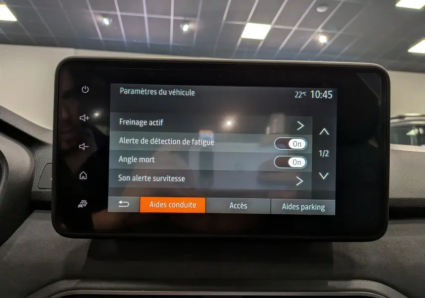 Écran tactile central affichant les paramètres d’aides à la conduite du Dacia Sandero Stepway gris schiste, vue de face.