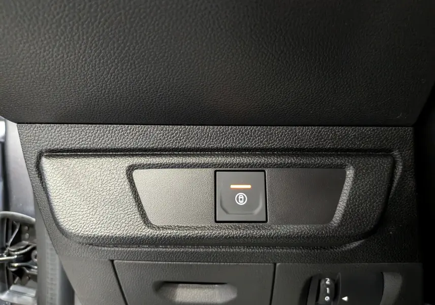 Gros plan sur le bouton de verrouillage centralisé orange dans l’habitacle noir du Dacia Sandero Stepway 2025.