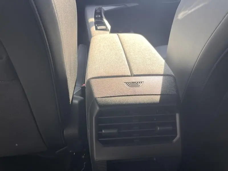 Vue rapprochée de l'accoudoir central arrière et des aérateurs noirs entre les sièges avant du Peugeot 3008 gris Artense.