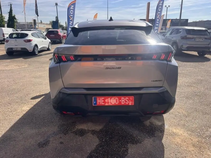 Vue arrière d'un Peugeot 3008 Hybrid gris Artense avec feux arrière LED caractéristiques et plaque d'immatriculation rouge.