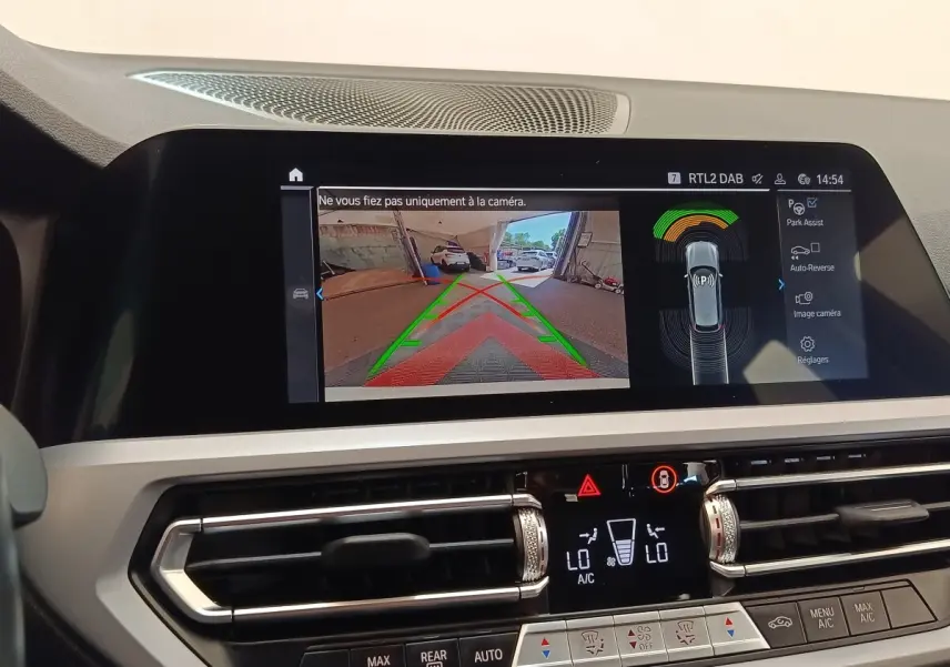 Écran tactile intérieur montrant la caméra de recul et l’aide au stationnement dans une BMW Série 3 blanche.