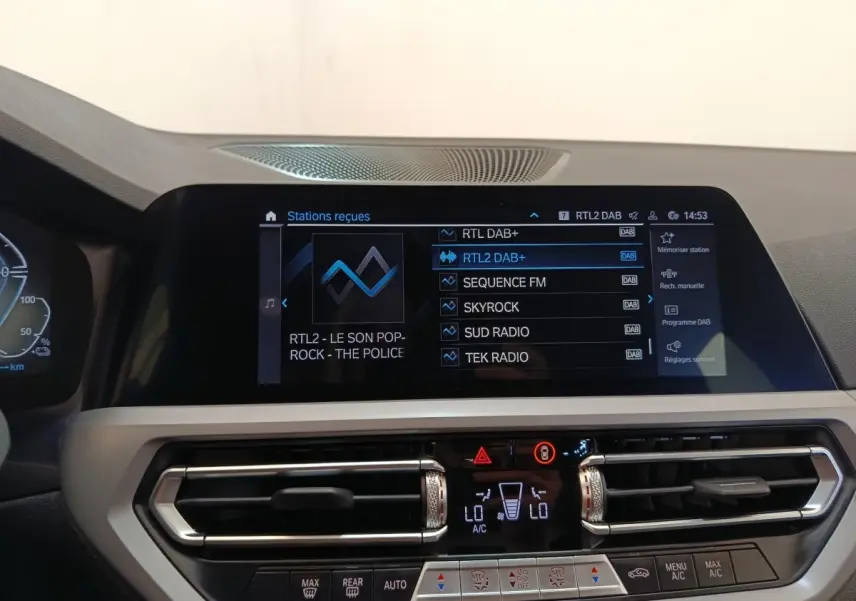 Vue rapprochée de l’écran tactile central et des commandes de climatisation d’une BMW Série 3 320e hybride rechargeable.