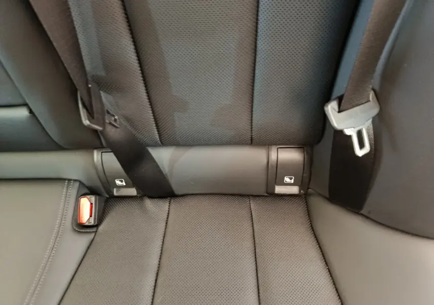 Gros plan sur la banquette arrière noire perforée avec ceintures et fixations Isofix visibles dans une BMW Série 3 320e hybride.