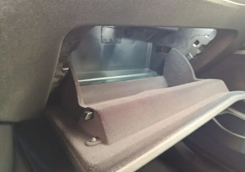 Vue rapprochée de la boîte à gants ouverte de la BMW Série 3 320e blanche, intérieur noir.