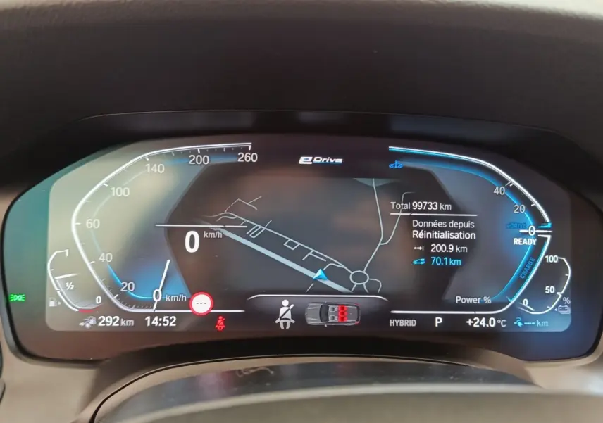 Tableau de bord numérique BMW Série 3 320e hybride, affichage vitesse, navigation et état batterie en vue frontale.