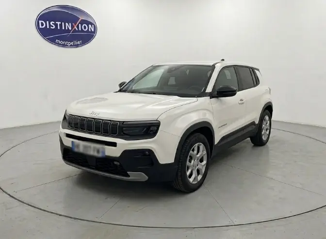 Jeep Avenger blanc en 3/4 avant droit, avec calandre noire distinctive et éléments de protection noirs sur les bas de caisse.