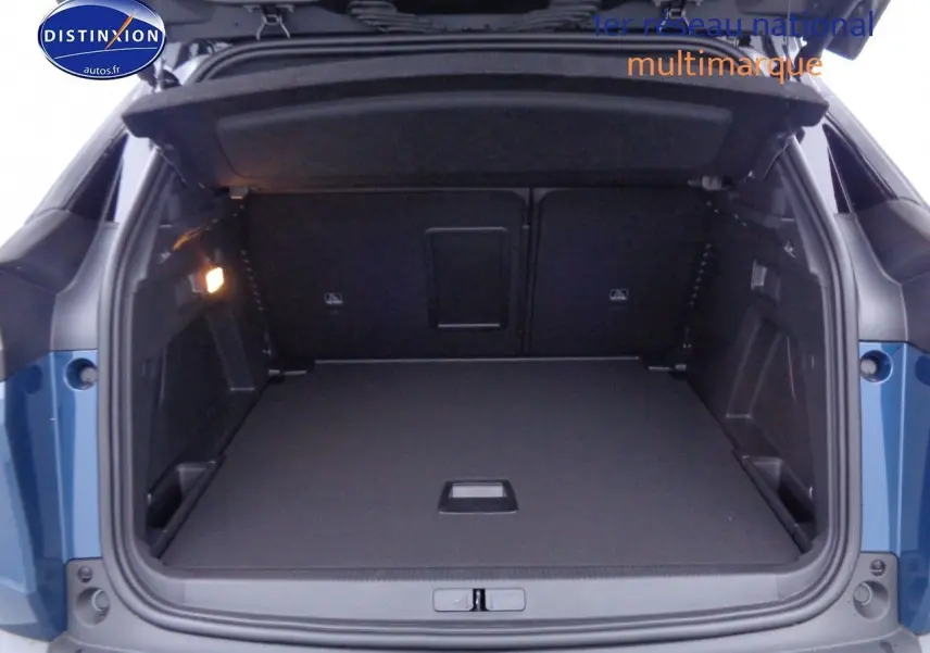 Coffre ouvert en vue arrière d’un Peugeot 3008 2023 bleu Celebes Metal, montrant un espace de chargement spacieux et bien éclairé.