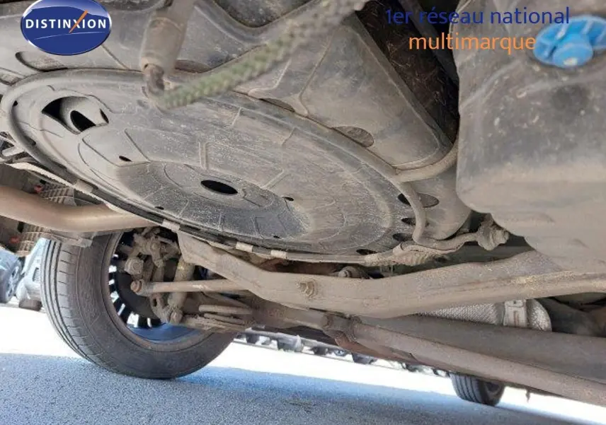 Vue en contre-plongée sous l'Opel Zafira noire métal, montrant le train arrière et la roue gauche.